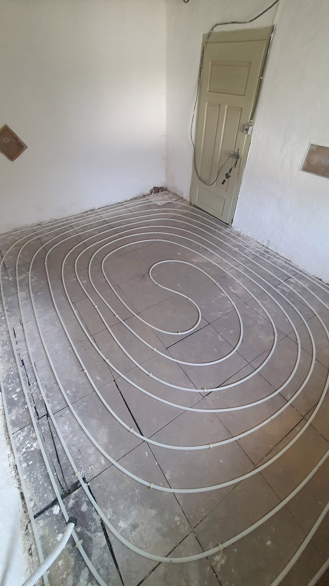 Hier is de buis helemaal gelegd, in een klassiek slakkenhuispatroon. We hebben behoorlijk uitgezocht welke vorm het slimste is (net als bij de wandverwarming), en dit patroon geeft de beste warmtespreiding. Wel de toevoer als buitenste doen, want de kou komt van de zijkanten. Hier is de buis helemaal gelegd, in een klassiek slakkenhuispatroon. We hebben behoorlijk uitgezocht welke vorm het slimste is (net als bij de wandverwarming), en dit patroon geeft de beste warmtespreiding. Wel de toevoer als buitenste doen, want de kou komt van de zijkanten.